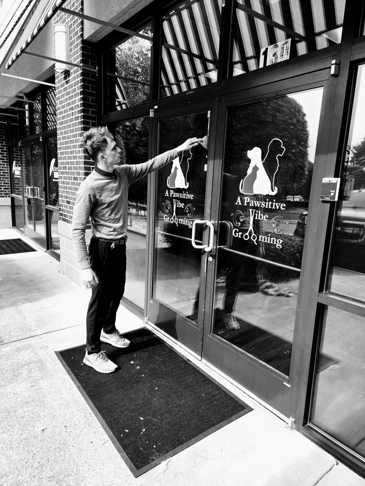 Window cleaning in progress at a glass storefront entrance